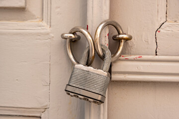 Padlock on grey wooden door close up, closed secured house entrance. Traditional door detail