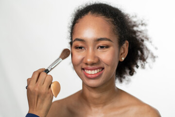 Thai-African American girls make up using a pink blush on white background.Makeup and beauty concept.