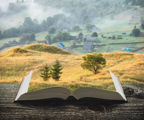 Misty village on the pages of book