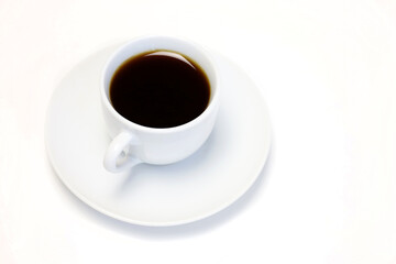 Coffee cup and saucer on a white table, top view