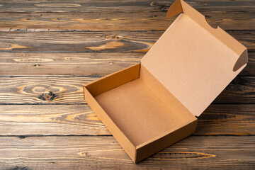 One open cardboard box on wooden background