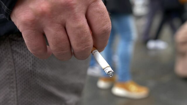 Close up boy hand with burning cigarette in hand. Smoking addiction. Video 4K