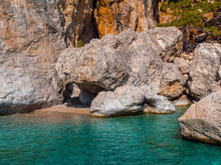 Crystal clear sea water and a small beach just enough for a couple, under the shadow of a rock formation