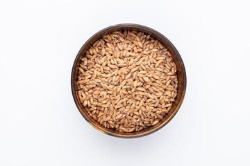 Wheat grains and wooden bowl on white background.