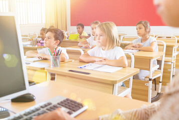 Fototapeta premium Group of happy school pupils raise their hands up