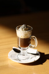Viennese coffee in a beautiful glass on a plate