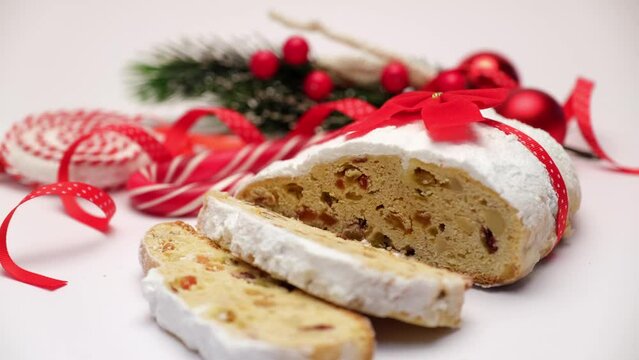Sliced Traditional Christmas stollen cake with marzipan and dried fruit isolated on white background