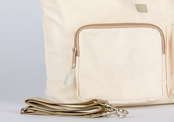 Closeup studio shot of hand opening showing inside compartments of cream beige color multifunction...