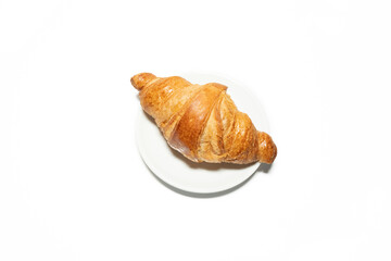 General plan of a complete breakfast on a mat, to start the day with strength. It contains raspberries, blueberries, coffee with a small jug of milk, panela, croissant, a plant and a book to enjoy.