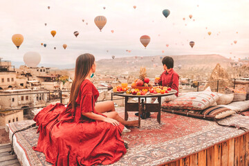 Couple Travel in Cappadocia Colorful hot air balloons flying over the valley sunrise time with...