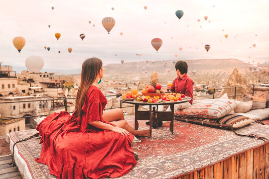 Couple Travel in Cappadocia Colorful hot air balloons flying over the valley sunrise time with special breakfast travel destination in Turkey