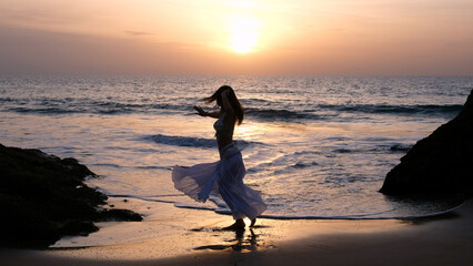 Woman dances to the sun wearing arabic dance costume. Fertility concept. Exotic beauty.