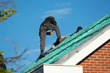 Man working on roof constructing building house 