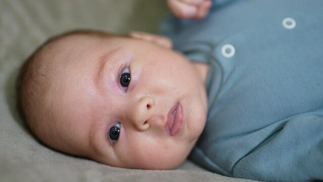 Lovely baby face lying on one check. Portrait of a child staring directly into camera. Close up.