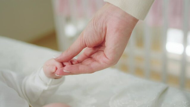 Happy Smiling Little Baby Laying Down On The Bed While Some Adult Playing From Above Concept Of Nursing Care Motherhood And Baby Childhood