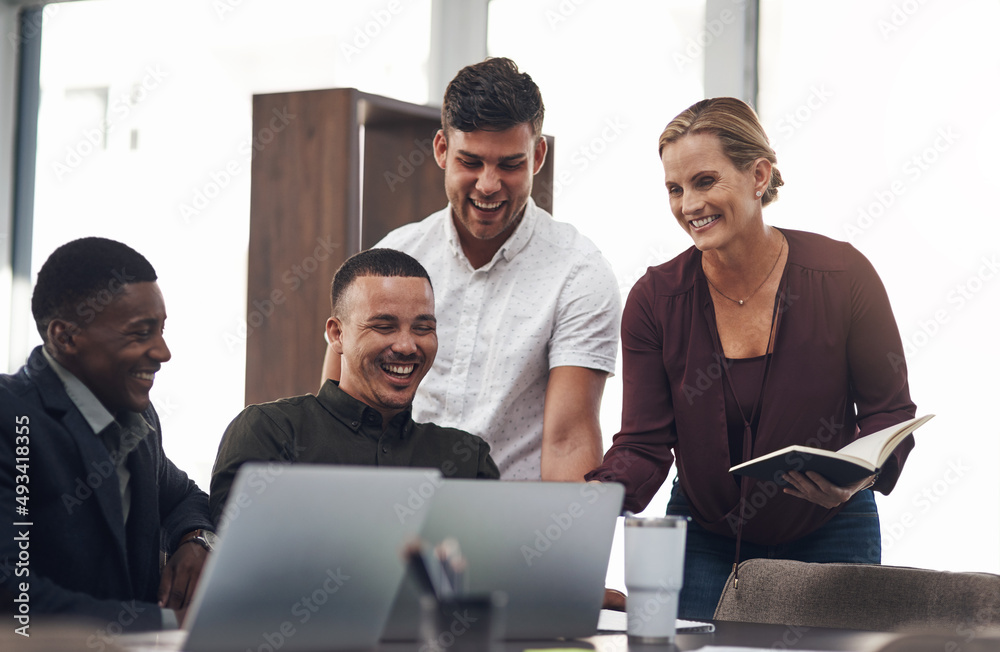 Wall mural Seeing their plan all come together. Shot of a group of businesspeople working together on a laptop in an office.