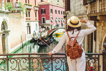 young pretty woman traveler standing at venice bridge cross canal