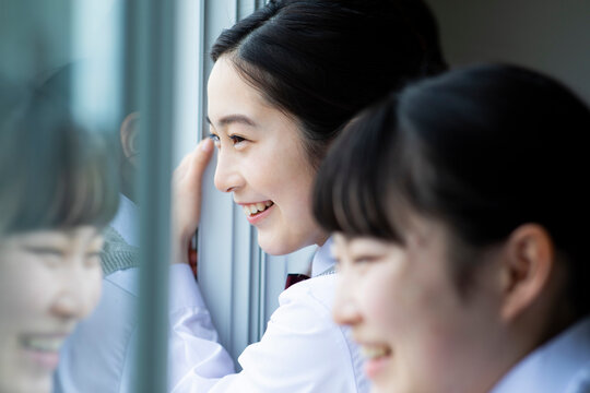 Fototapeta 教室の窓の外を眺める笑顔の女子校生