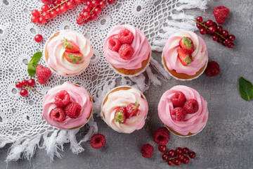 Pink cupcakes with cream and fresh berries