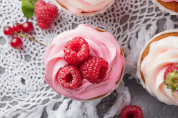 Pink cupcakes with cream and fresh berries