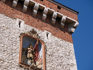 St. Florian's Gate or Florian Gate (Brama Floriańska Kraków). Gothic tower, part of historic fortifications in the Old Town of Krakow, Poland. Bas-relief depicting Saint Florian. - obrazy, fototapety, plakaty