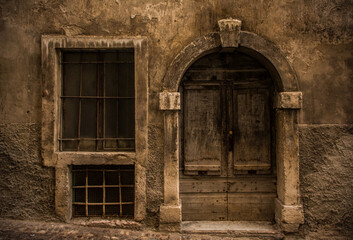 An historic wooden door in a derelict medieval building in central Rovereto in Trentino, north east Italy
