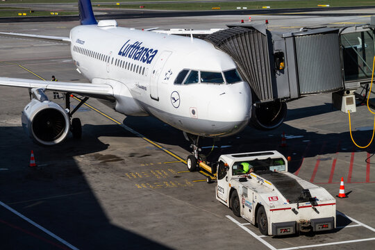 Lufthansa Airbus A319 with a jet bridge and an airplane tow truck hooked up on the front landing gear, at Frederic Chopin International Airport Warszawa Okęcie on April 17, 2019 in Warsaw, Poland.