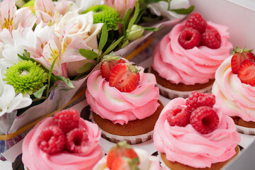 Pink cupcakes with cream and fresh berries