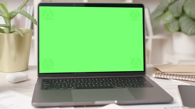 Laptop Computer with Green Screen in Cozy Office Interior