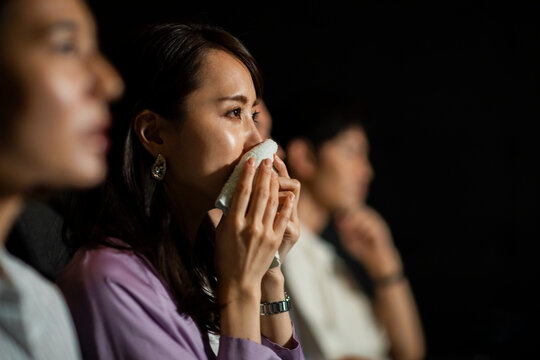 映画を観て涙をハンカチで拭う女性