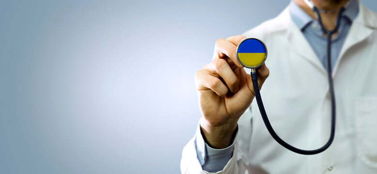 Ukraine medical help and support - healthcare worker showing stethoscope with Ukraine flag. banner copy space