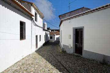 Fototapeta na wymiar Typical narrow street lined with white houses, Serpa city, Alentejo, Portugal