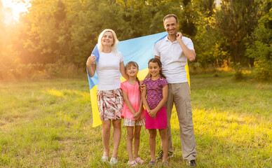 Fototapeta na wymiar Ukraine's Independence Flag Day. Constitution day. family with the flag of ukraine in field. 24 August. Patriotic holiday.