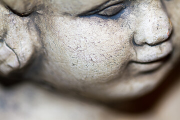 Weathered stone face of an angel or cherub