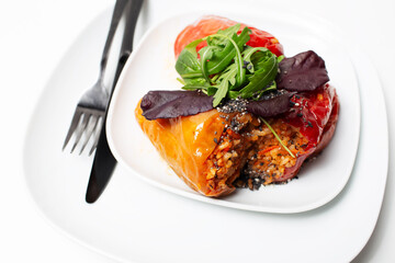 Homemade vegan meal. Stuffed peppers with rice, mushrooms, served with rucola.