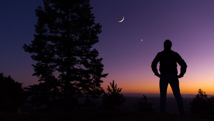 Man observing evening sky with stars, planets and crescent Moon.