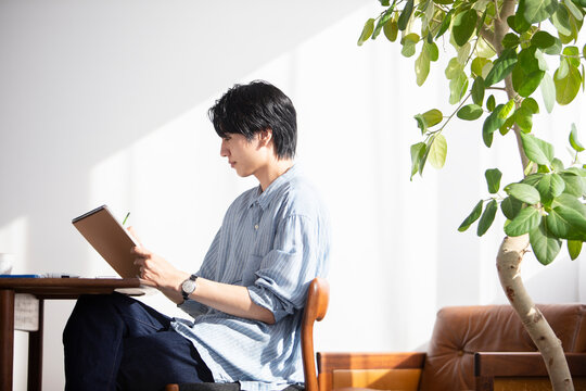 リビングで絵を描く男性