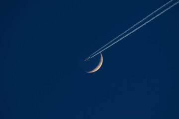 Crescent Moon with airplane con-trail.