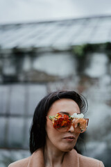 Portrait of the young woman with the glass from flowers. Blind concept