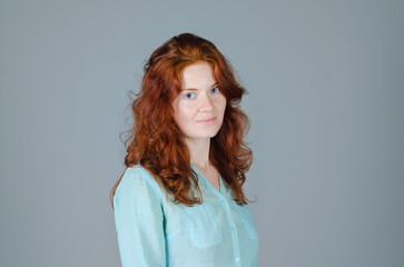 Fototapeta premium Business portrait of beautiful young woman with red curly hair and blue eyes against colorful background. Lifestyle.