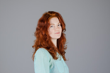 Fototapeta premium Business portrait of beautiful young woman with red curly hair and blue eyes against colorful background. Lifestyle.