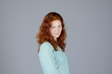 Fototapeta premium Business portrait of beautiful young woman with red curly hair and blue eyes against colorful background. Lifestyle.