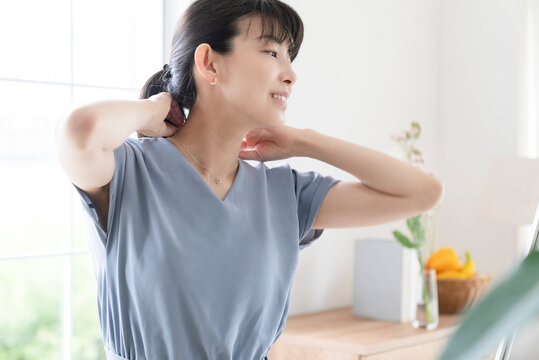 鏡を見ながらアクセサリーを身につける女性
