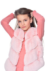 Happy little girl posing in fur waistcoat on white background