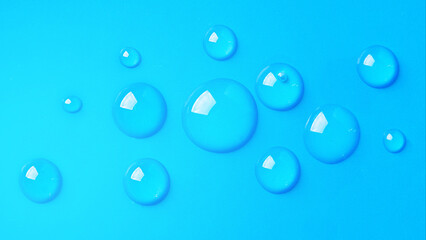 Water drops on blue background. Abstract drops of gel. Face serum cosmetics.