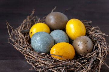 Close up of Easter eggs in birds nest on wooden table. Happy Easter concept. Top view.