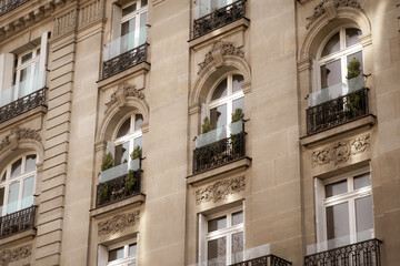 Beautiful facade of a building from Paris, France, with a lot of plants and elegant architecture details and decorations.