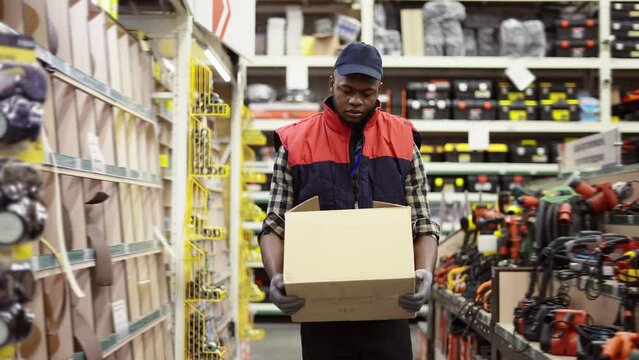 Worker in hardware store carrying box