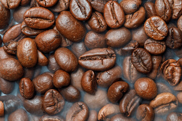 close-up large roasted coffee beans in smoke