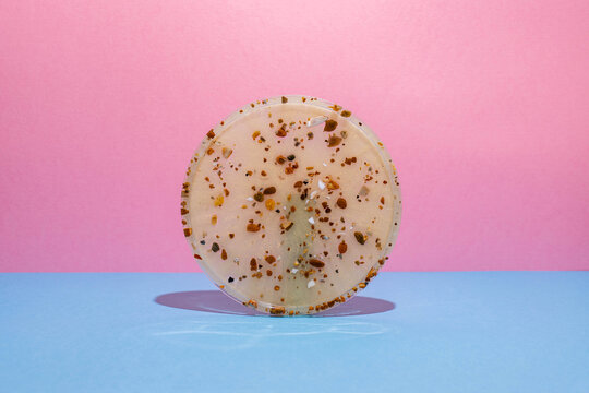 Studio photo of beige round resin terrazzo platter tray,  on pink and blue background